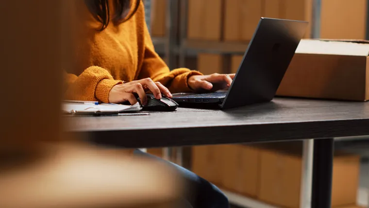 Operatore al laptop in un magazzino logistico